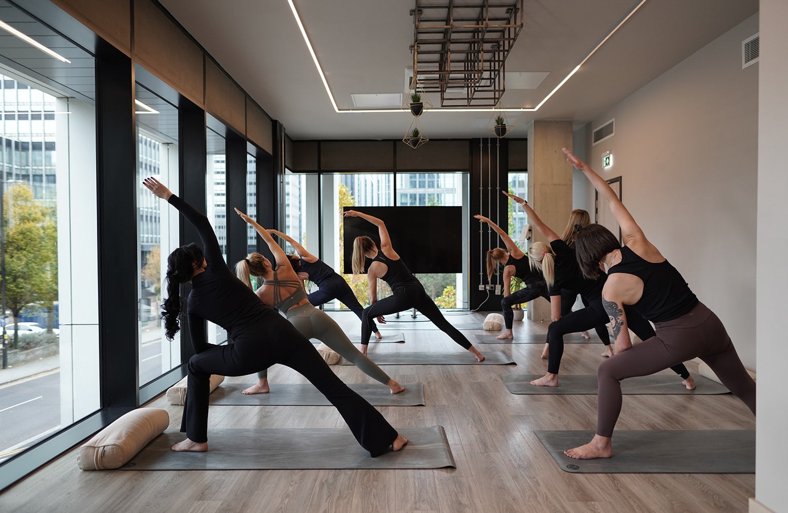 A group of students in a yoga class completing a pose on yoga mats.