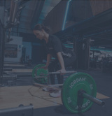 A female in a gym using the trap bar deadlift
