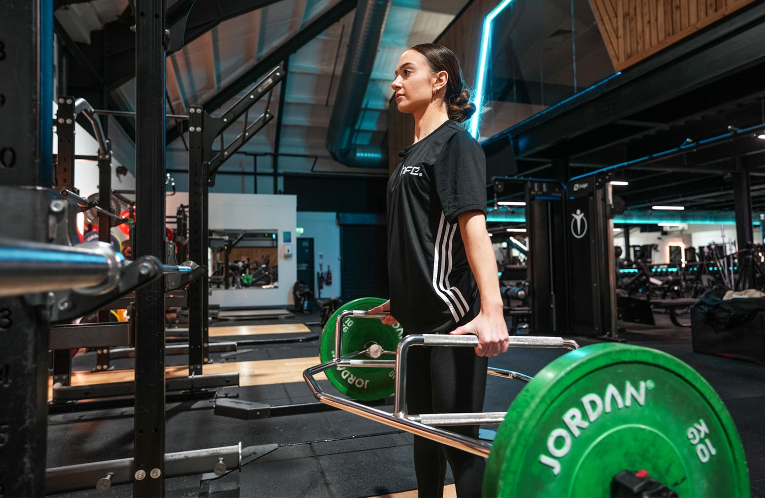 A female in a gym using the trap bar deadlift