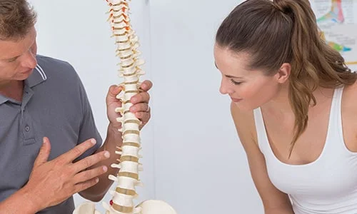 A healthcare provider showing a client the anatomy of the spine
