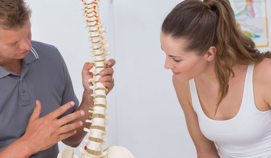 A healthcare provider showing a client the anatomy of the spine