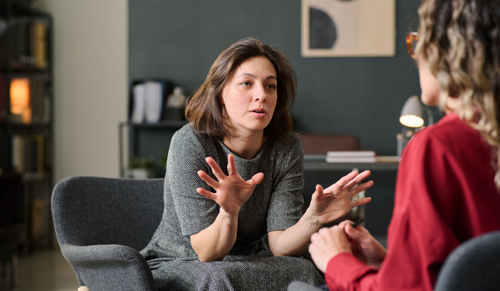 A health coach speaking to a client in a professional office setting