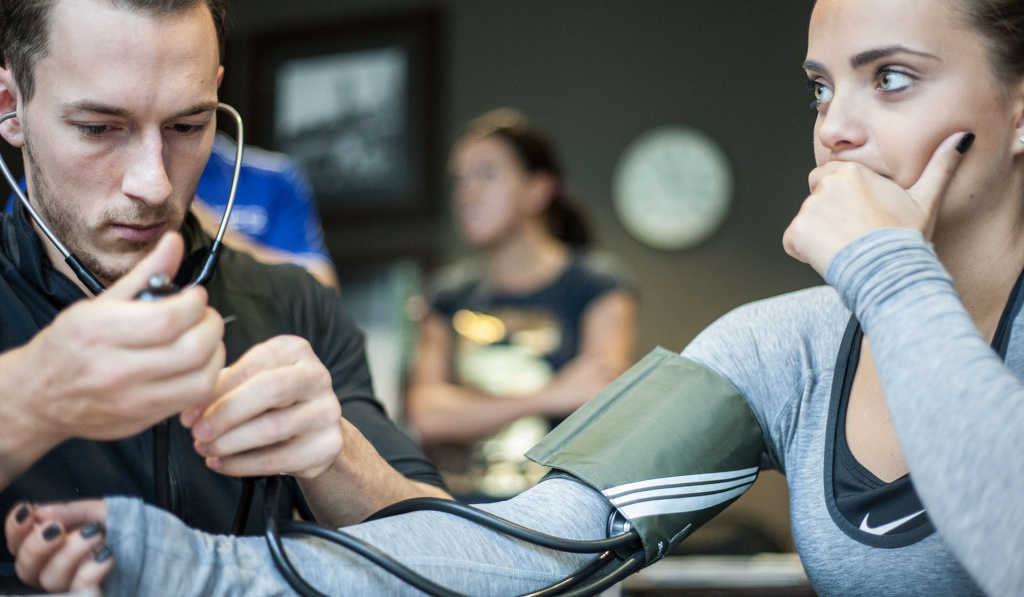 A male and female student using a stethoscope on a HFE exercise referral course