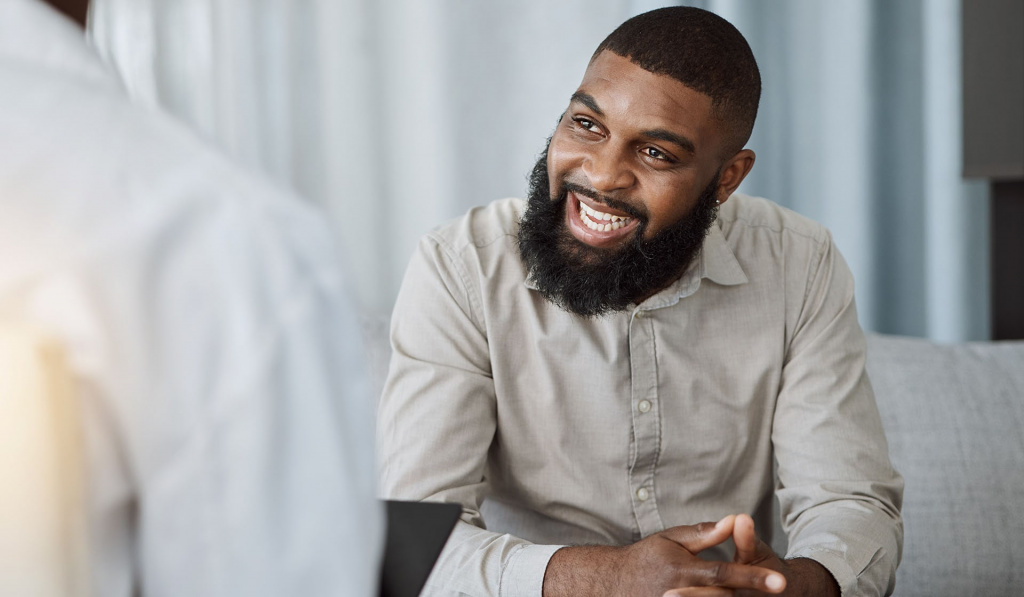 A young male sat with a healthcare provider while smiling A young male sat with a healthcare provider while smiling