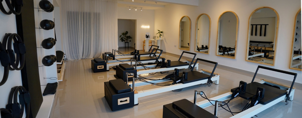 A reformer Pilates studio, which has five reformer Pilates machines, with mirrors in front of each one