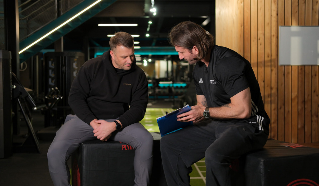 A personal trainer completing a client consultation in a gym setting