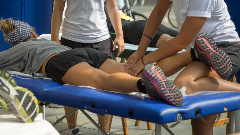 elite athlete receiving hamstring massage at sports event