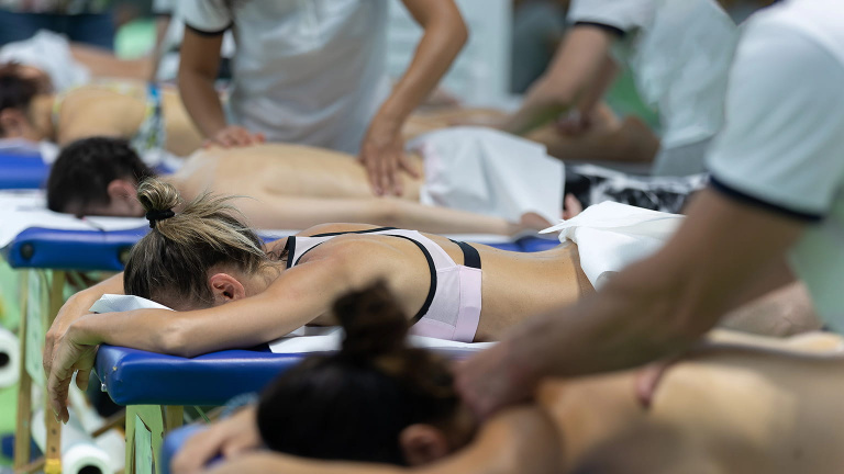 group of athletes at event having sports massage