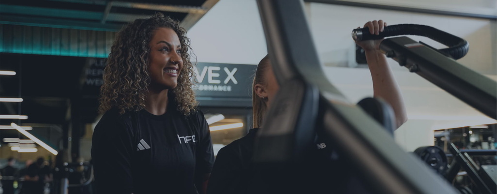 A female PT supporting a female in a gym